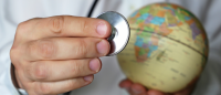 Hands holding stethoscope and globe
